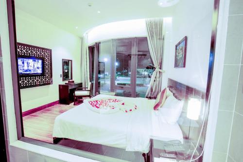 Ly Son Pearl Island Hotel & Resort في Ly Son: إنعكاس لغرفة نوم مع سرير في نافذة