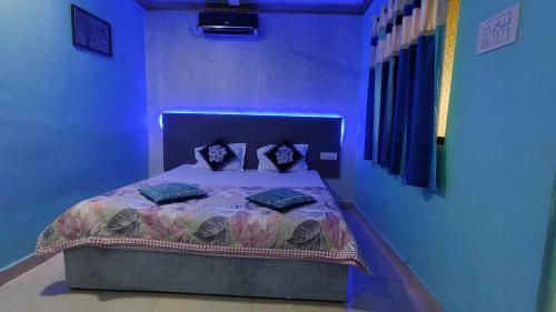 a blue bedroom with a bed with pillows on it at Ashirwad Cottage in Matheran