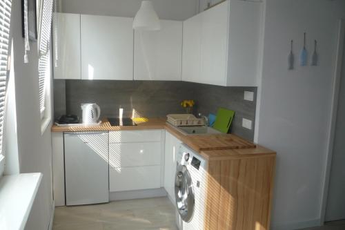 a kitchen with a washing machine and a sink at Mieszkanie Przy Plaży in Gdańsk