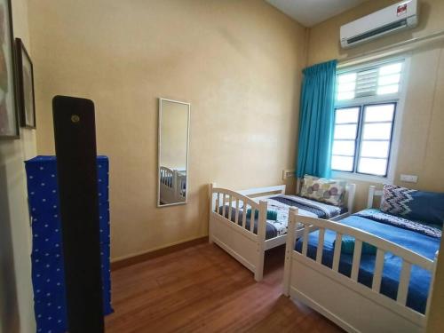 a nursery with two twin beds and a window at Cheerful 6BR Town House @ Geortown for 5-14pax by Cohans in George Town