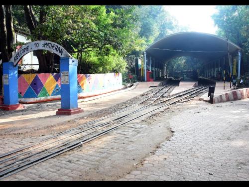 a train station with train tracks in front of it at Ashirwad Cottage in Matheran