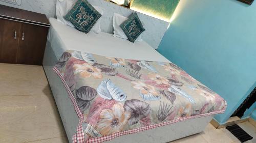 Una cama con colcha floral. en Ashirwad Cottage, en Matheran