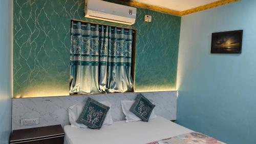a room with a bed and a window with curtains at Ashirwad Cottage in Matheran