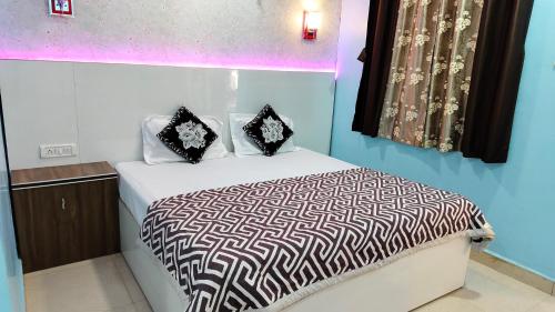 a bed with black and white sheets and pillows at Ashirwad Cottage in Matheran