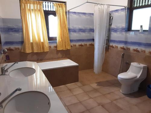 a bathroom with a toilet and a sink at Pahalage Guesthouse in Beruwala