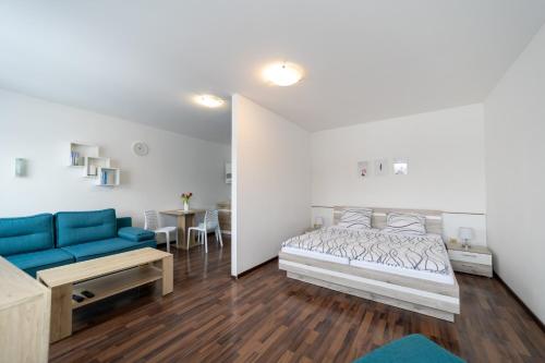 1 dormitorio con cama, sofá y mesa en Penzion Bludička, en Litomyšl