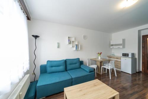 uma sala de estar com um sofá azul e uma mesa em Penzion Bludička em Litomysl