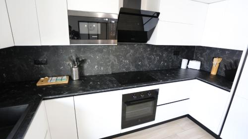 une cuisine avec des armoires blanches et un comptoir noir dans l'établissement Bel appartement T3 à louer, à Marseille