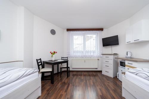 a bedroom with a bed and a table and a kitchen at Penzion Bludička in Litomyšl