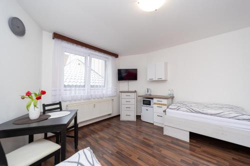 a bedroom with a bed and a desk and a table at Penzion Bludička in Litomyšl