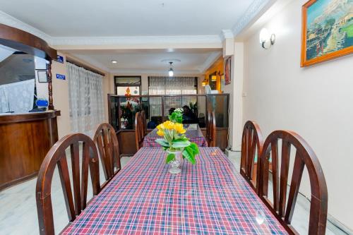 a dining room table with a vase of flowers on it at OYO 801 Hotel View Global in Kathmandu