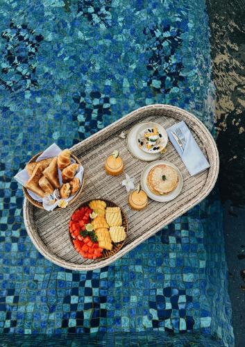 a tray of food on a table in a swimming pool at Kula Kara Villas Uluwatu in Uluwatu