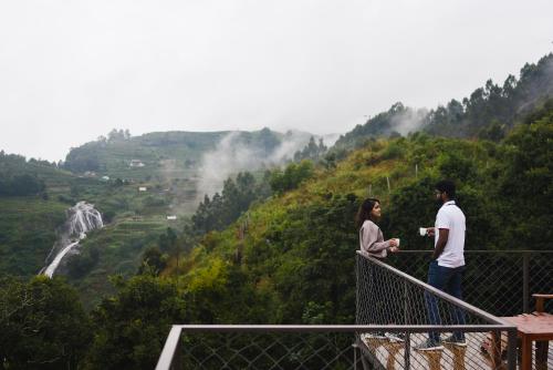 a man and a woman standing on a ledge overlooking a valley at LUXEGLAMP ECOSTAYS in Kūkkāl