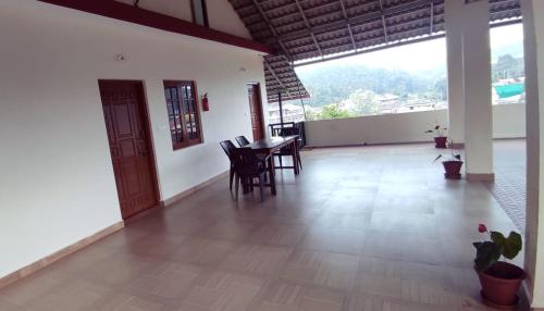 uma sala de jantar com uma mesa e cadeiras num quarto em Nellakki Homestay em Madikeri