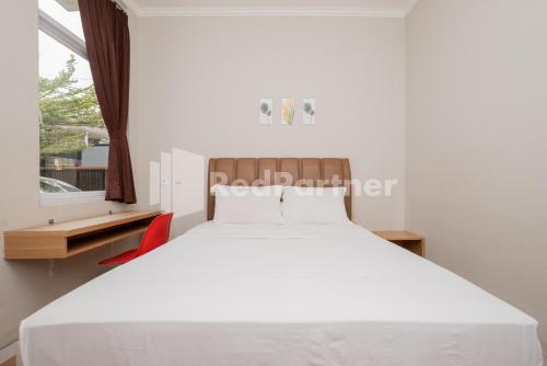 a bedroom with a white bed and a window at Palm Eight Mitra RedDoorz in Jakarta