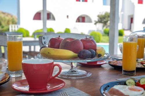 un tavolo con un piatto di frutta e una tazza di caffè di Depis Edem luxury villas naxos a Plaka