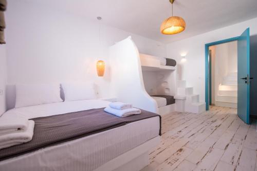 a white bedroom with a bed with towels on it at Depis Edem private villas naxos in Plaka