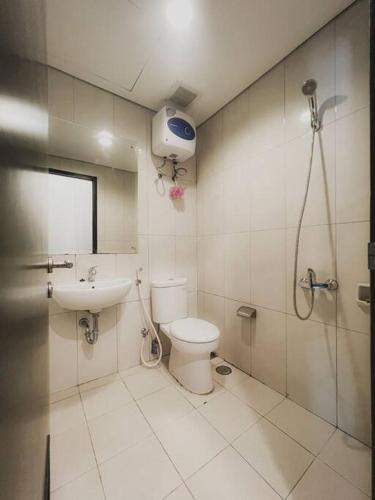 y baño con ducha, aseo y lavamanos. en Vintage Oasis Retro Studio at Nifarro Apartment, en Yakarta