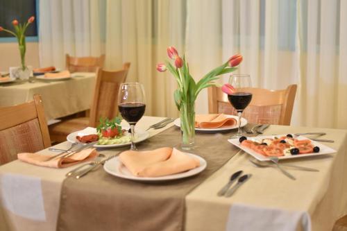 a table with plates of food and glasses of wine at Хотел Дикас in Smolyan