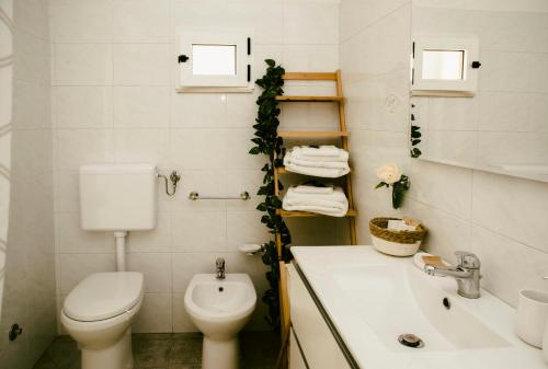 ein weißes Bad mit einem WC und einem Waschbecken in der Unterkunft Le 3 Volte in Cursi