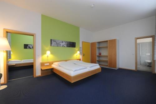 um quarto com uma cama grande e um espelho em Bildungs- uns Tagungshäuser Vierzehnheiligen Diözesanhaus em Bad Staffelstein