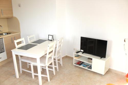 kuchnia z białym stołem z krzesłami i telewizorem w obiekcie Relax en primera linea A w mieście El Campello