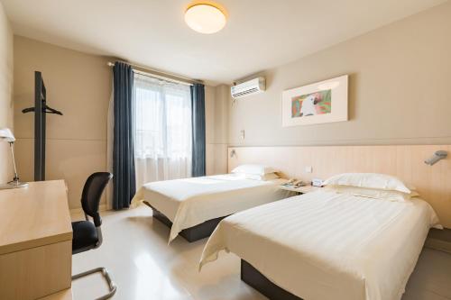 a hotel room with two beds and a window at Jinjiang Inn Shanghai Light Textile Market Caoan Road in Shanghai