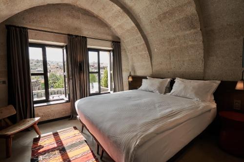 a bedroom with a large bed and a large window at Carus Cappadocia in Goreme