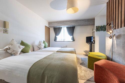 a hotel room with a large bed and a window at Racine難波 in Osaka