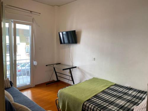 a living room with a bed and a tv on the wall at Travelers in Athens in Athens