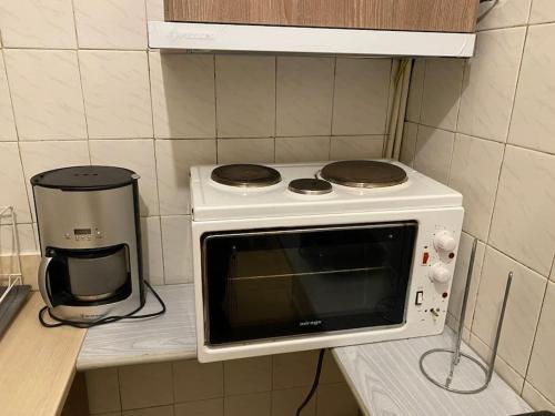 a microwave sitting on a counter next to a coffee maker at Travelers in Athens in Athens