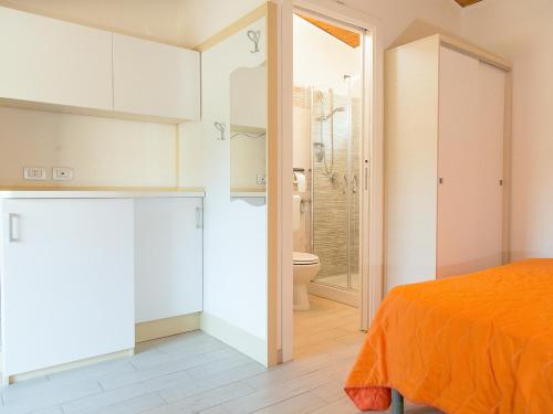 a bedroom with an orange bed and a bathroom at Arco delle Rose Rooms in Agropoli