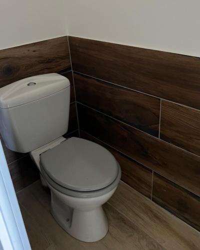 a white toilet in a bathroom with wooden walls at Mini Villa St-Lucie Porto-Vecchio vue mer 5mnplage in Zonza