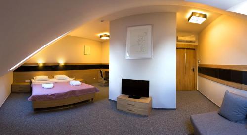 Cette chambre comprend 2 lits et une télévision. dans l'établissement Hotel KARO, à Radom