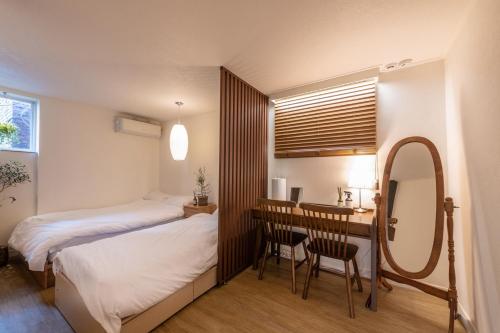 1 dormitorio con cama, escritorio y espejo en MaSilRo, en Seúl