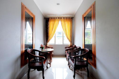 a dining room with chairs and a table and a window at RedDoorz Syariah at Delta Sari Aloha Waru in Sidoarjo