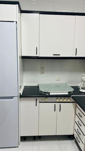 cocina con armarios blancos y encimera en Apartamento Don Pedro, en Valencia de Alcántara