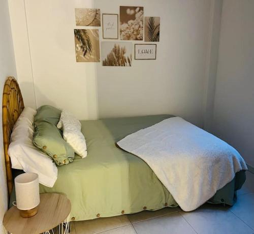 Un dormitorio con una cama verde con almohadas y una mesa. en Apartamento Don Pedro, en Valencia de Alcántara