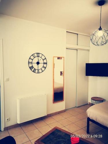 a room with a clock on the wall and a mirror at Le Puits d'Amour in Villeneuve-sur-Yonne