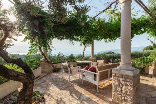 a patio with a table and chairs under a tree at Villa Roza in Splitska
