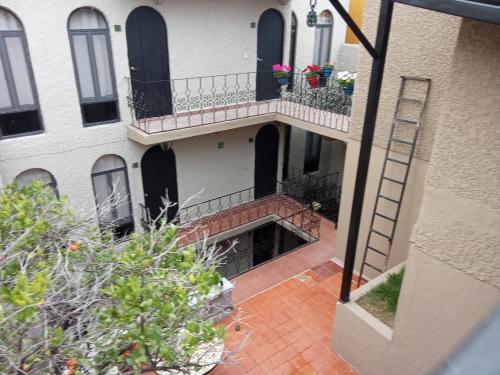 an apartment building with a staircase and a balcony at Hotel Suspiro in San Miguel de Allende