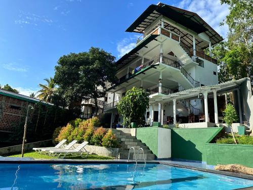 una casa con piscina frente a ella en Green Hill Paradise Villa, en Unawatuna
