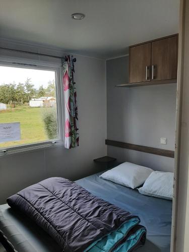 une chambre avec un lit et une fenêtre dans l'établissement Bungalow à la Baie de Kernic, à Plouescat