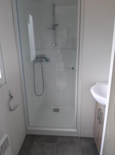 une salle de bain avec douche et lavabo dans l'établissement Bungalow à la Baie de Kernic, à Plouescat