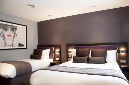 Una habitación de hotel con dos camas y un cuadro en la pared. en EPIC Apartments Tunnage Square, en Liverpool