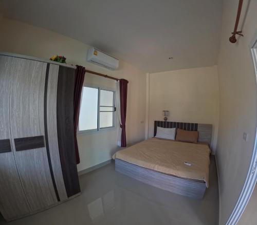 a small bedroom with a bed and a window at Pattaya pool villa in Ban Huai Yai