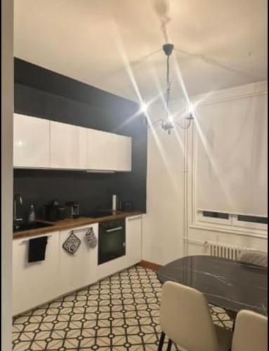 eine Küche mit einem Tisch und Stühlen im Zimmer in der Unterkunft Appartement haussmanien rénové proche centre Lausanne in Lausanne