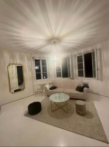 uma sala de estar com uma mesa e um sofá em Appartement haussmanien rénové proche centre Lausanne em Lausanne