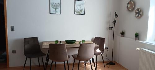 a dining room table with chairs and a green bowl on it at Ferienappartment Schneiderbanger in Bad Wildungen