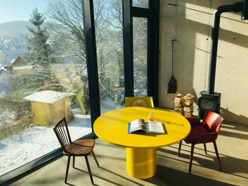 una mesa amarilla y sillas frente a una ventana en Ferienapartment Burgstrasse Ost, en Altleiningen